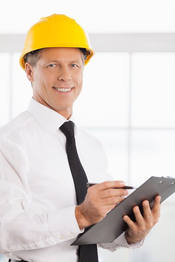 Responsabile della sicurezza con elmetto che prende appunti